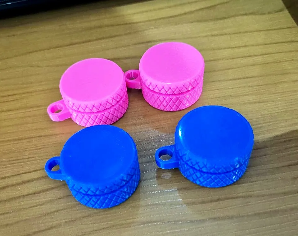 Quatro porta-comprimidos redondos com tampa texturizada e argola, dois rosa e dois azuis