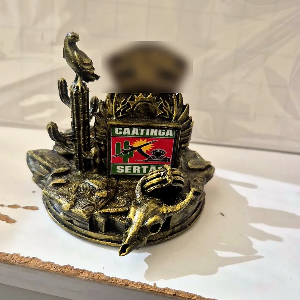 Troféu dourado envelhecido com cacto, ave, crânio de boi e brasão Caatinga Sertão (placa com nome desfocada)